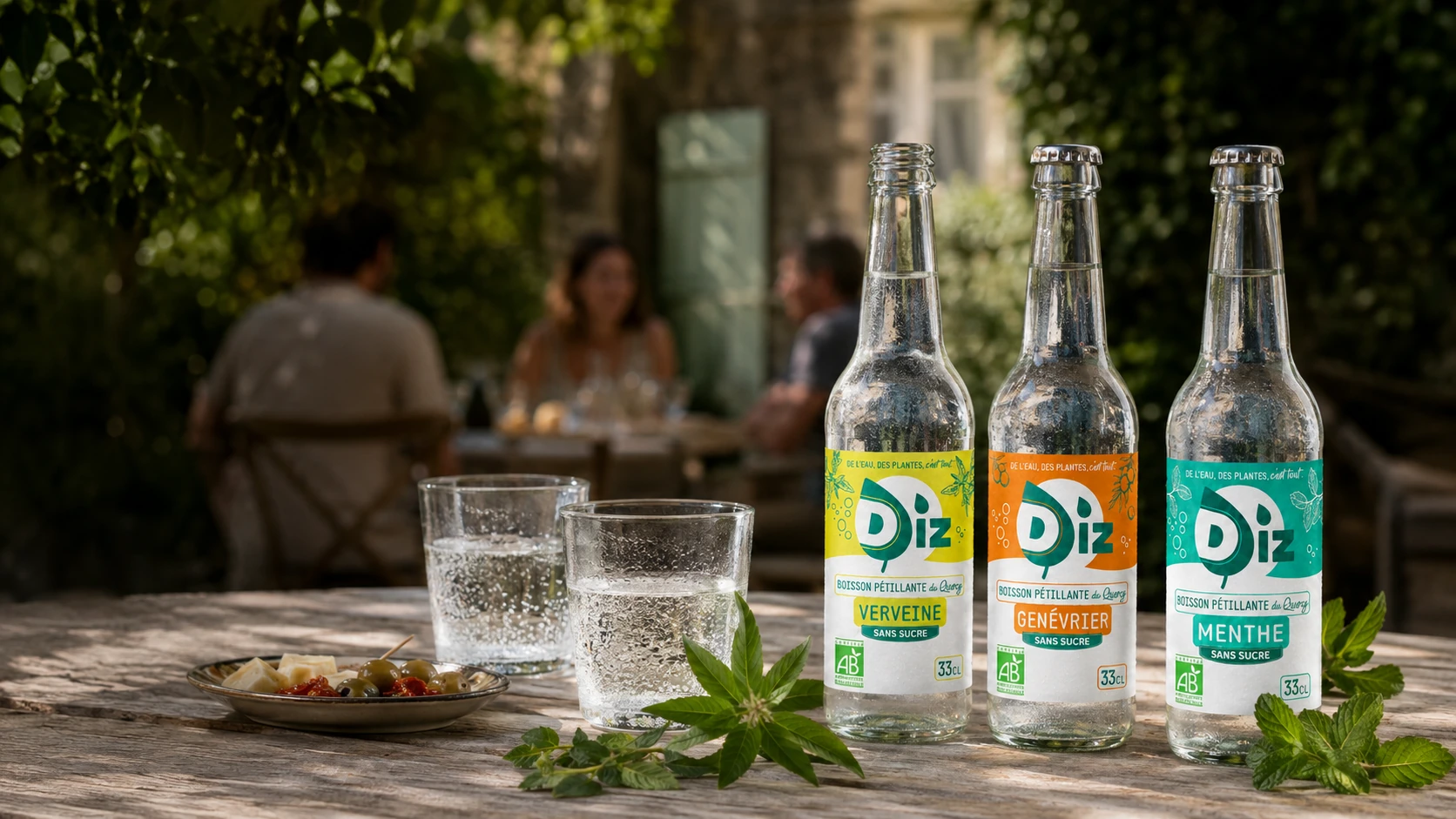 Bouteilles DIZ Verveine, Genévrier et Menthe servies sur une table dans un jardin